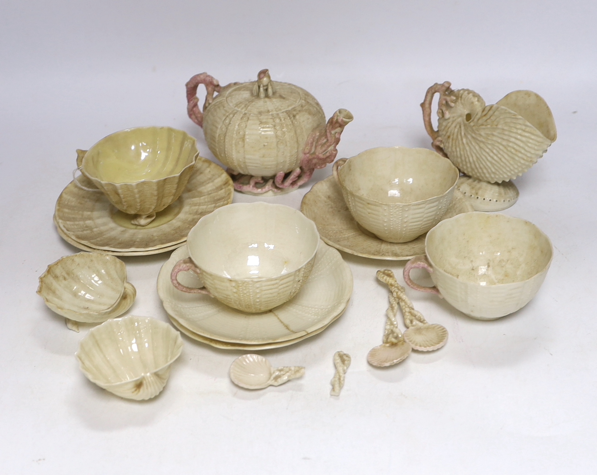 A quantity of Belleek including a teapot, three cups and saucers and a shell design vase, mostly first period